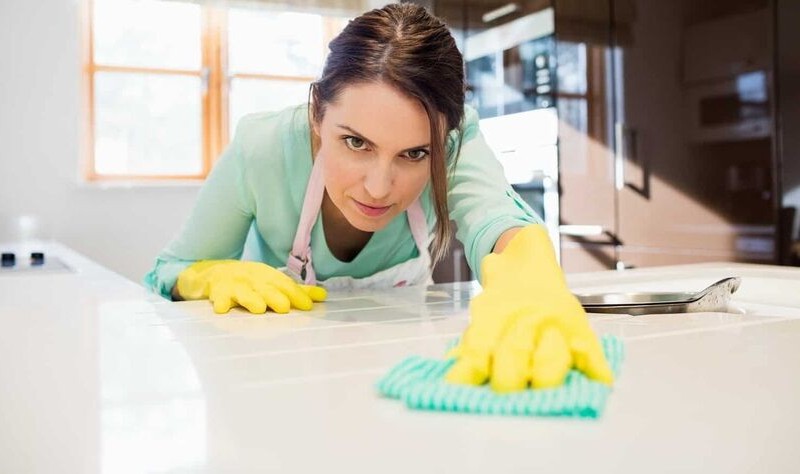 a woman is disinfecting her house