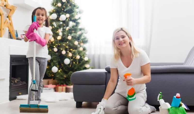 young woman sprucing up her house for her daughter for christmas