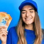 young woman with some money in her hand looking happy