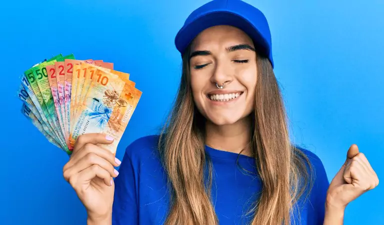 young woman with some money in her hand looking happy