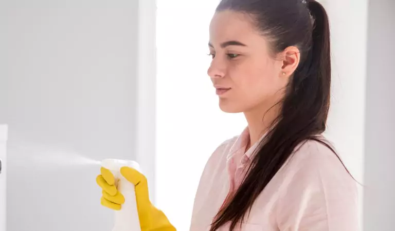young woman with a cleaning spray