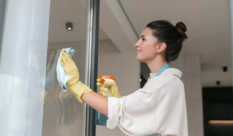 woman cleaning a shower glass
