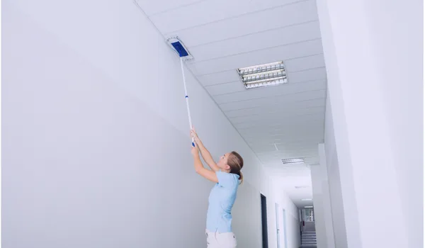 A woman cleaning the ceilings