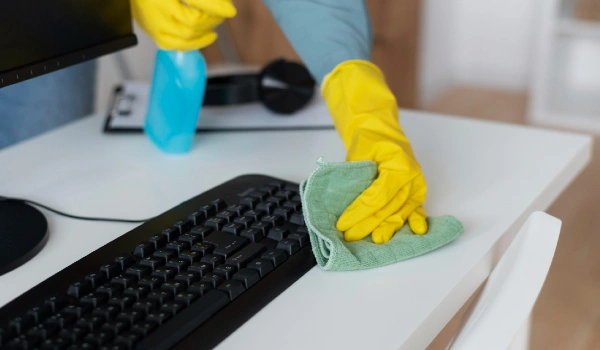 Person taking care of office desk cleaning