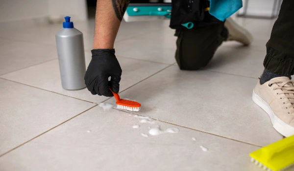 Man doing professional home cleaning service and cleaning tiles