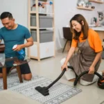 Happy asian couple cleaning their living room together