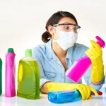 Detergent bottles gloves and woman with mask or glasses for protection safety and cleaning at home housekeeping cleaner