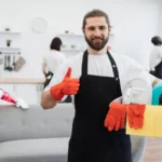 Portrait of bearded caucasian man cleaning worker holding bucket with detergents