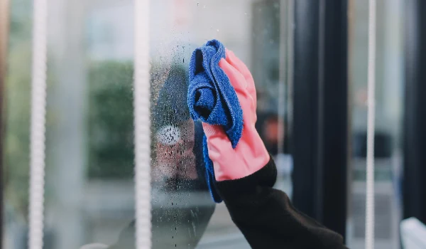 Professional cleaning service in overalls washes the glass of the windows